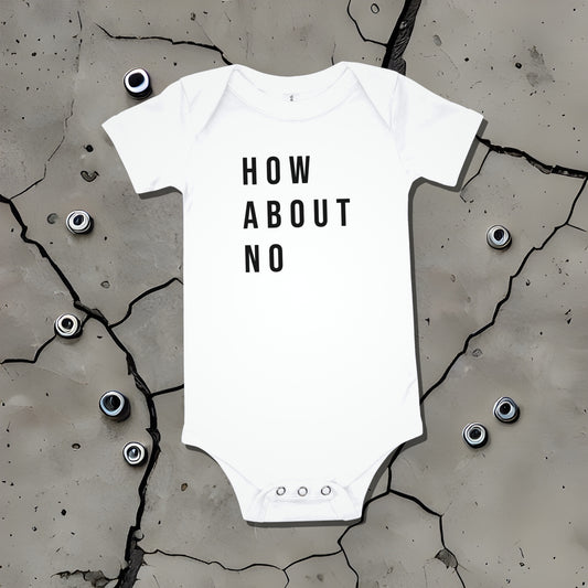White baby bodysuit with "HOW ABOUT NO" text displayed on a cracked surface. A bold statement baby clothes design conveying sarcastic attitude from Born Brash.