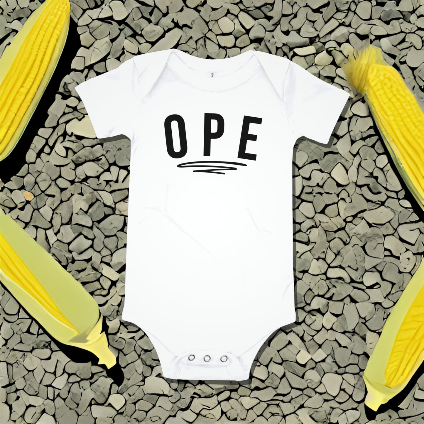White baby bodysuit with "OPE" text underlined, on a gray textured background with corn illustrations. A funny humorous and relatable baby clothes design with regional charm from Born Brash.