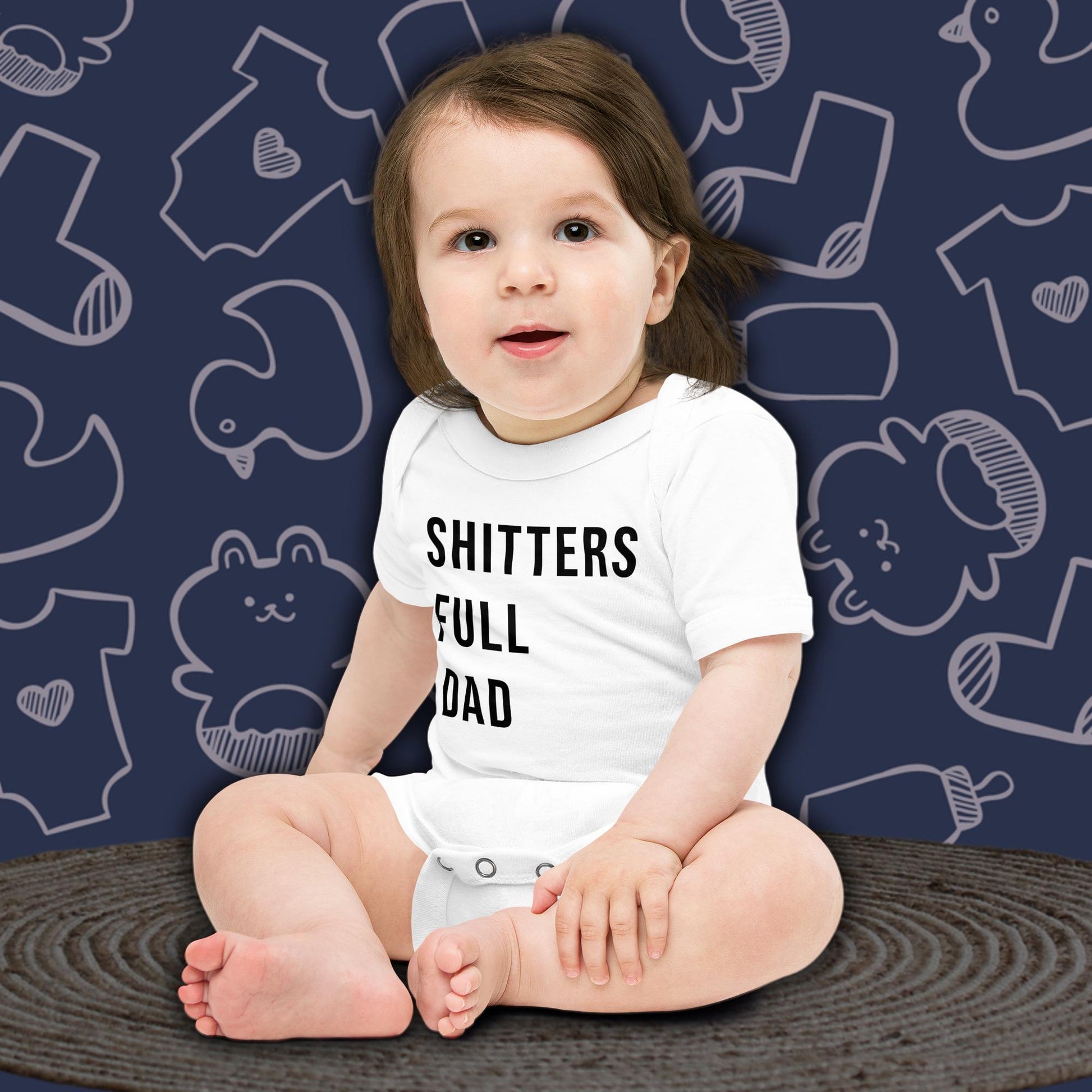 A cute baby with dark hair, sitting and looking forward, wearing a funny, white Born Brash bodysuit that says 'Shitters Full Dad'. The background is dark blue with white doodle patterns of baby bodysuits, baby toys, and baby bottles. Perfect for a funny newborn gift for fans of Christmas Vacation or a fun pregnancy announcement.