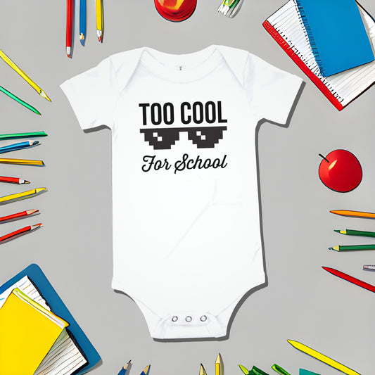 White baby bodysuit with "TOO COOL For School" text and pixelated sunglasses on a gray background with school supply illustrations. A funny humorous cool baby clothes design with a rebellious statement from Born Brash.