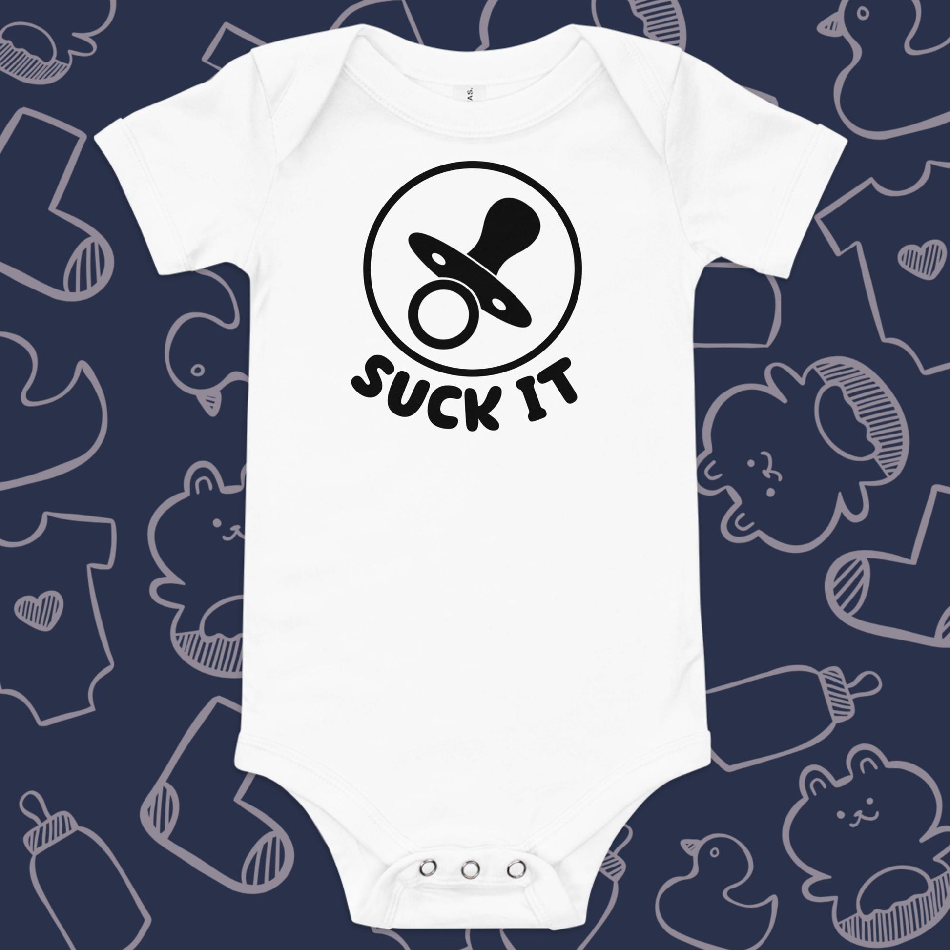 Funny, white baby onesie featuring an image of a pacifier and the playful text "SUCK IT" against a whimsical, blue backdrop of ducks, socks, stuffed animals, baby bodysuits, and bottles
