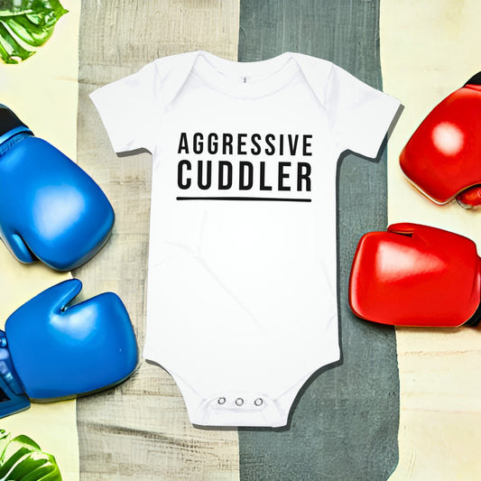 White baby bodysuit with "AGGRESSIVE CUDDLER" text on a split background with boxing gloves. A funny humorous and bold baby clothes design about aggressive cuddling from Born Brash.