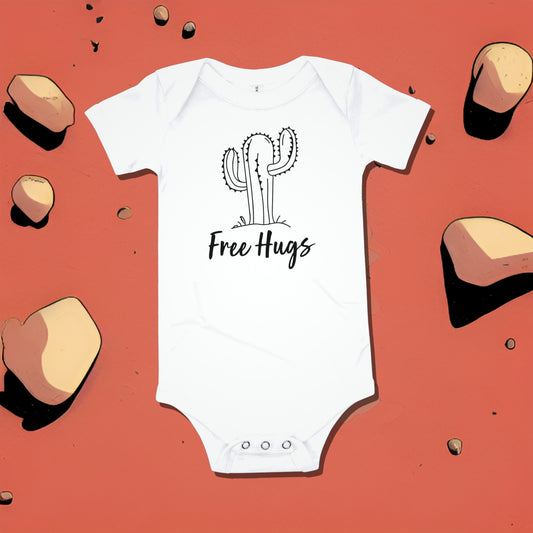 White baby bodysuit with a cactus illustration and "Free Hugs" text on a red background. A funny ironic humorous baby clothes design from Born Brash.