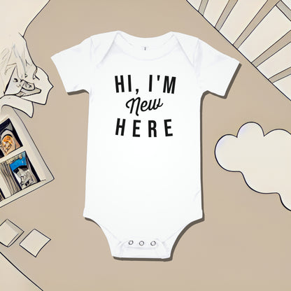 White baby bodysuit with "HI, I'M New HERE" text on a beige background with nursery illustrations. A funny humorous baby clothes design for a new arrival or baby shower gift from Born Brash.