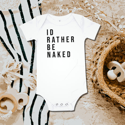 White baby bodysuit with "ID RATHER BE NAKED" text on a fuzzy blanket with striped fabric and basket. A funny humorous and relatable baby clothes design about not wanting to wear clothes from Born Brash.