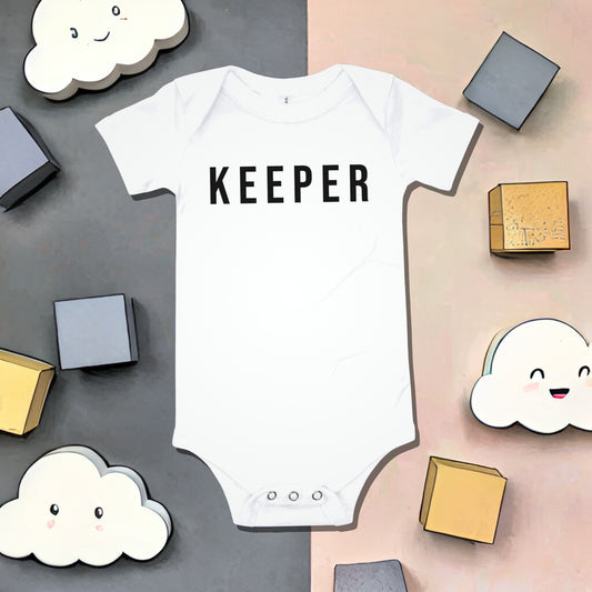 White baby bodysuit with "KEEPER" text on a split background with blocks and smiling cloud illustrations. A funny humorous and sweet baby clothes design acknowledging a special baby, perfect as a unique baby shower gift from Born Brash.