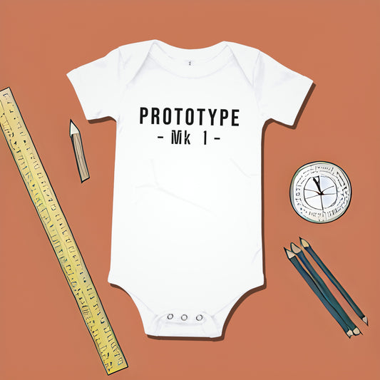 White baby bodysuit with "PROTOTYPE - Mk 1 -" text on an orange background with ruler and pencil illustrations. A funny humorous and relatable baby clothes design for new parents from Born Brash.