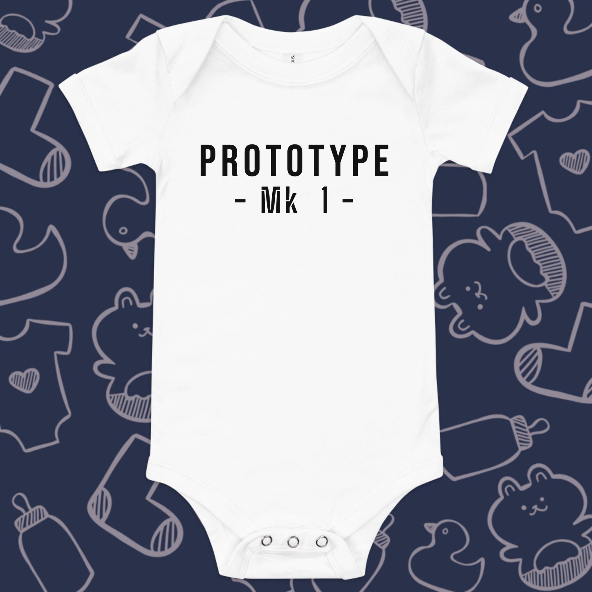 Funny, white baby onesie featuring the playful text "PROTOTYPE MK 1" against a whimsical, blue backdrop of ducks, socks, stuffed animals, baby bodysuits, and bottles