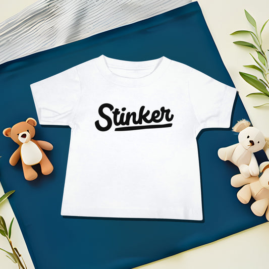 White baby t-shirt with "Stinker" text on a split diagonal background with teddy bear and leaf illustrations. A funny humorous and sweet baby t-shirt design calling the baby a "Stinker," making it a great baby shower gift from Born Brash.
