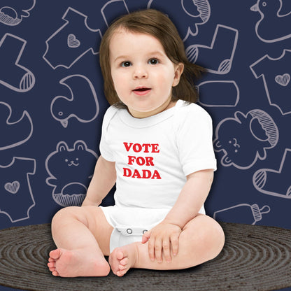 A cute baby with dark hair, sitting and looking forward, wearing a white Born Brash bodysuit that says 'Vote for Dada'. The background is dark blue with white doodle patterns of baby bodysuits, baby toys, and baby bottles. Perfect for a funny newborn gift or pregnancy announcement.