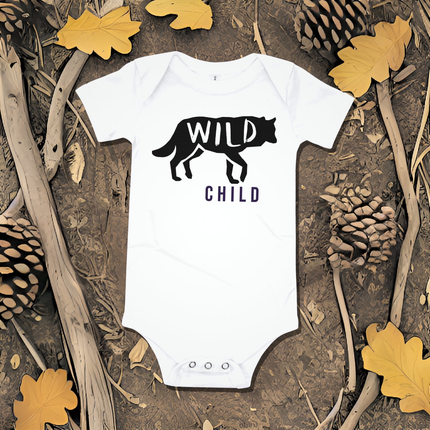 White baby bodysuit with a wolf silhouette graphic and "WILD CHILD" text on a background of bark, pinecones, and oak leaves. A bold unique baby clothes design perfect as a baby shower gift from Born Brash for little wild ones.