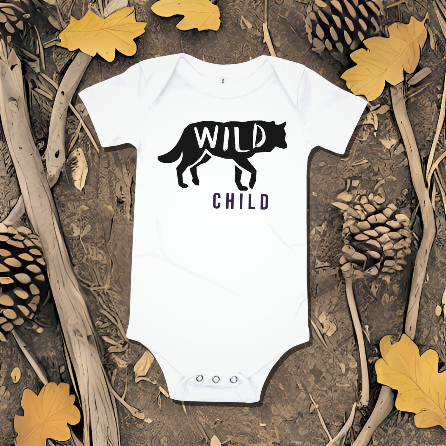 White baby bodysuit with a wolf silhouette graphic and "WILD CHILD" text on a background of bark, pinecones, and oak leaves. A bold unique baby clothes design perfect as a baby shower gift from Born Brash for little wild ones.
