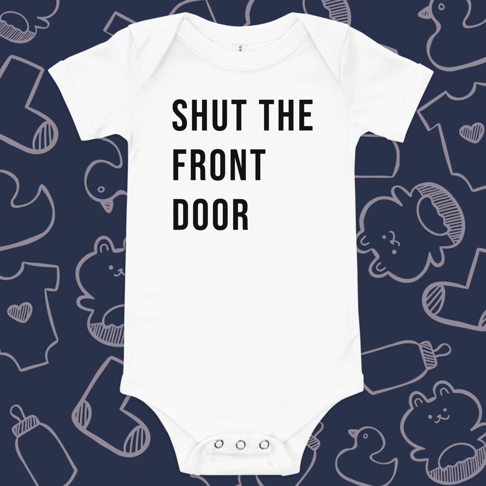 Funny, white baby onesie featuring the playful text "SHUT THE FRONT DOOR" against a whimsical, blue backdrop of ducks, socks, stuffed animals, baby bodysuits, and bottles