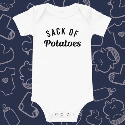 Funny, white baby bodysuit featuring the playful text "Sack of Potatoes" against a whimsical, blue backdrop of baby toys, bodysuits, and bottles.
